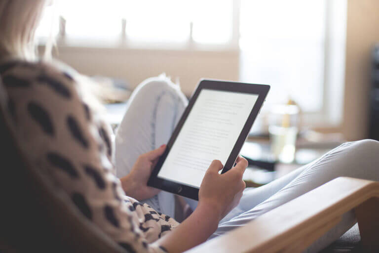 A woman reading on an iPod