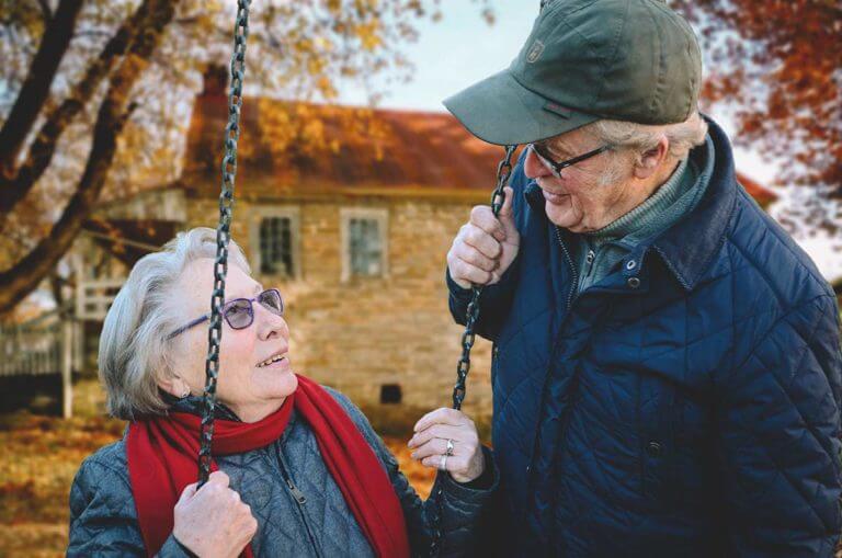 Senior man swinging a senior woman