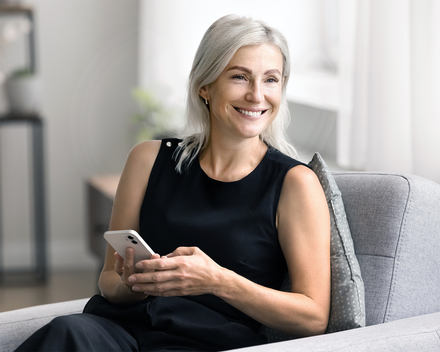 Mature woman using her phone at home